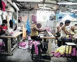 Abysmal conditions: Workers sew clothes in a garment factory owned by Mohammad Mustaqueem, in Dharavi slum, Mumbai. More than a warehouse for the poor,  Dharavi contains a hive of workshops with an annual economic output of more than Rs 3000 crore. NYT