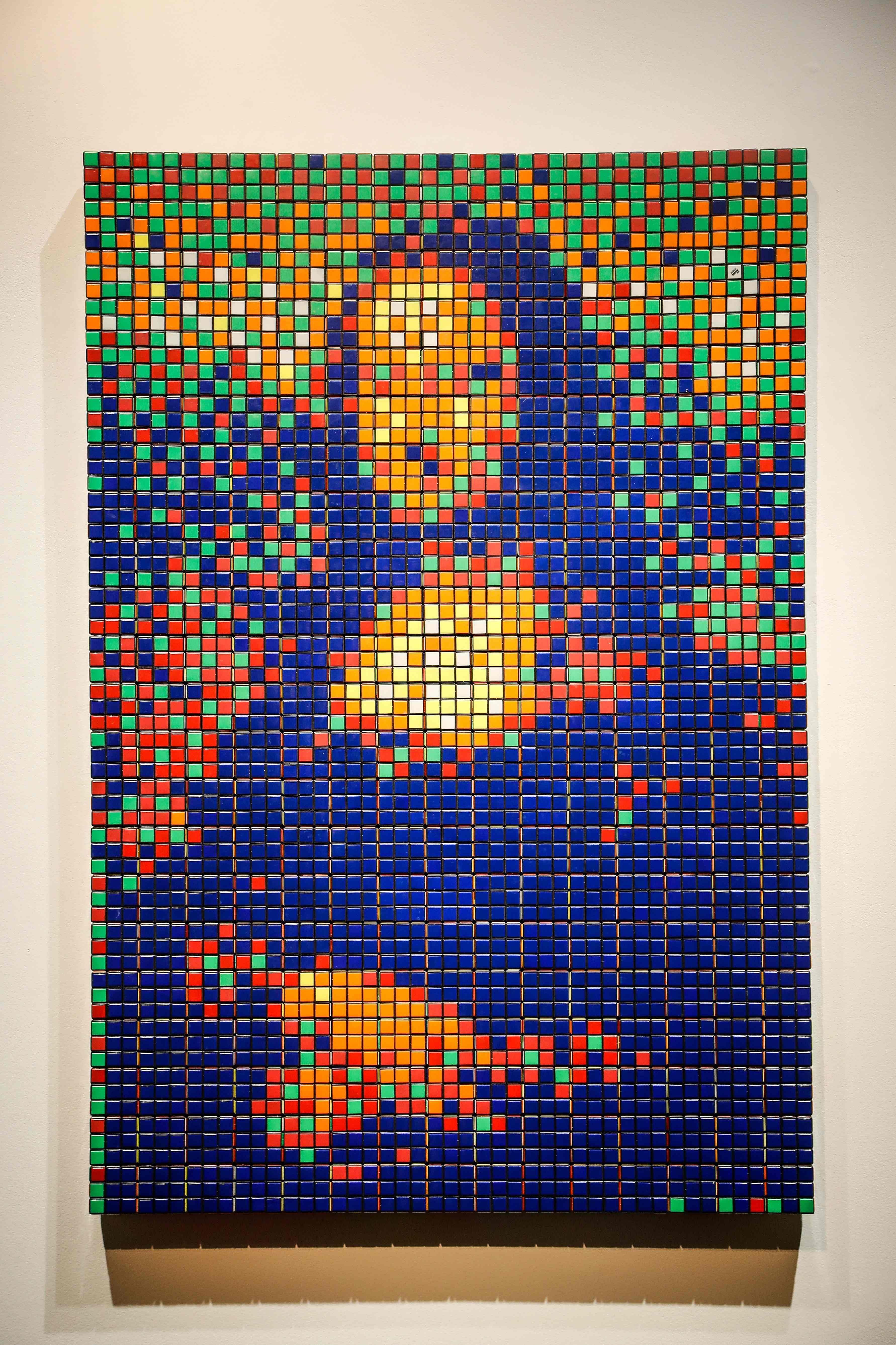 It uses the plastic puzzles' squares to create a mosaic of the Mona Lisa and her famous smile in garish colours. (Credit: AFP Photo)