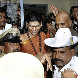 Police take away Swami Nityananda after he surrendered before a magistrate at a court in Ramanagara near Bengaluru on Wednesday. PTI Photo