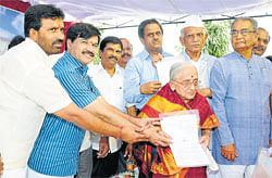 Just reward: District in-charge minister S&#8200;A&#8200;Ramdas gives away title deeds of MUDA sites to freedom fighters T&#8200;Puttanna, H&#8200;Javaregowda and Amruthamma in Mysore on Monday. MUDA chairman L&#8200;Nagendra, MLC&#8200;Siddaraju and MUDA&#8200;commissioner C&#8200;J&#8200;Betsurmath are seen. dh photo