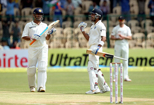 Virat Kohli (R) celebrates his century as Captain M S Dhoni applauds during the third day of their second cricket test match against New Zealand in Bengaluru on Sunday.PTI Photo