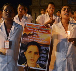 Nursing students sing while holding a poster depicting nurse Jacintha Saldanha during a candlelight vigil for her in Bangalore December 13, 2012. Jacintha Saldanha was found hanged, police told a coroner's inquest in London, days after the 46-year-old put the hoax call through to a colleague who disclosed details of the treatment being given to William's wife Kate, who is suffering from acute morning sickness. REUTERS