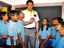 jumbos class: Cricketer and KSCA President Anil Kumble demonstrates a bowling technique to students of the Government Higher Primary School at Kundanahalli on the occasion of Shiksha Diwas in the City on Tuesday. dh Photo