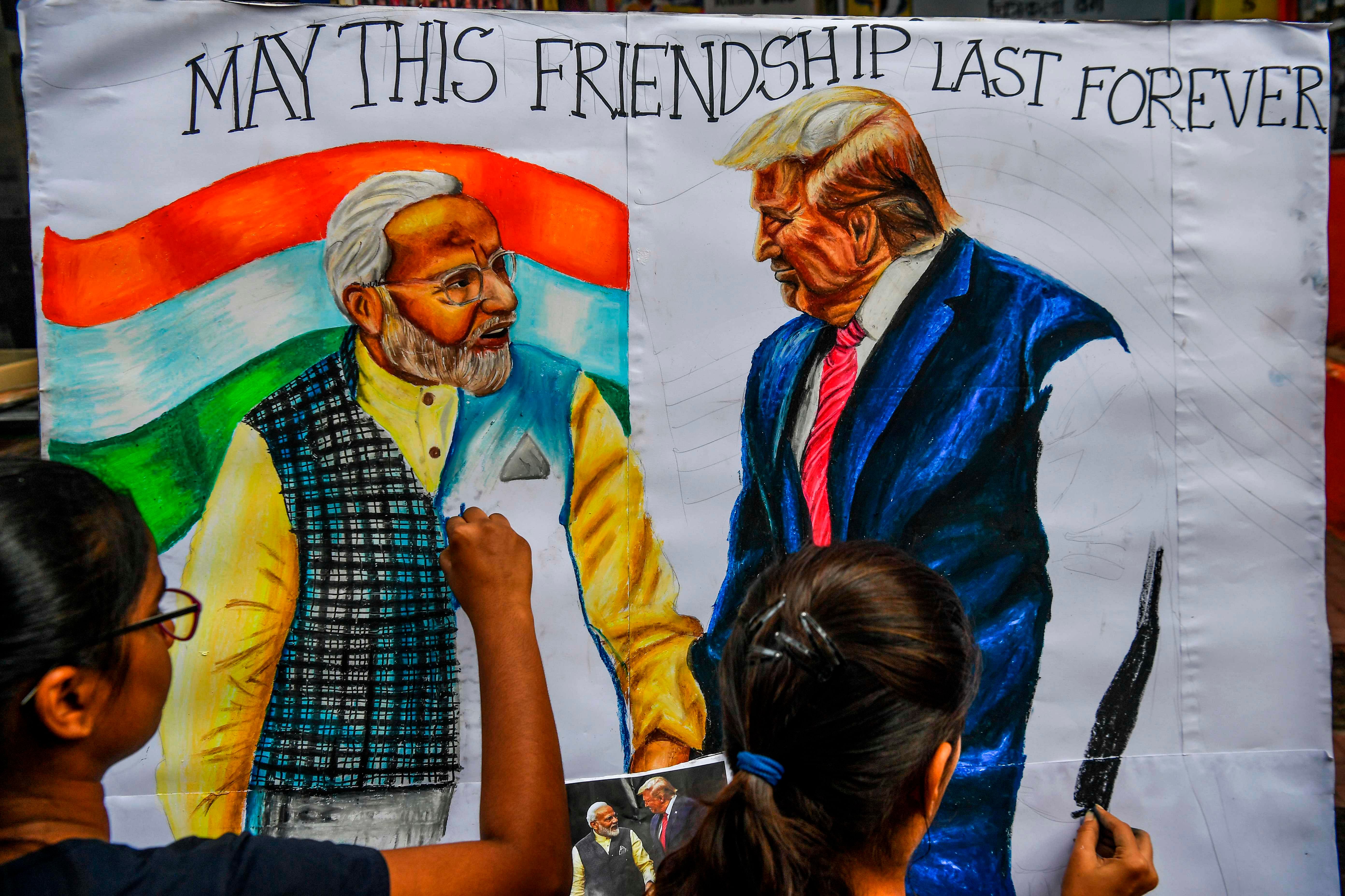 Students paint on canvas faces of US President Donald Trump (R) and Prime Minister Narendra Modi, in the street in Mumbai. (AFP Photo)