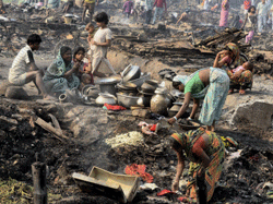 Slum dwellers search for their belongings after a major fire gutted around 700 shanties in Santoshpur-Maheshtala area in Kolkata on Saturday. PTI Photo