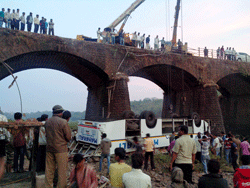 Rescuers and others gather at the site of a bus accident in Ratnagiri district, in the western Indian state of Maharashtra, Tuesday, March 19, 2013. The bus packed with passengers crashed through a guard rail and fell off the bridge in western India early Tuesday, killing at least 37 people and injuring another 15, police said. AP Photo