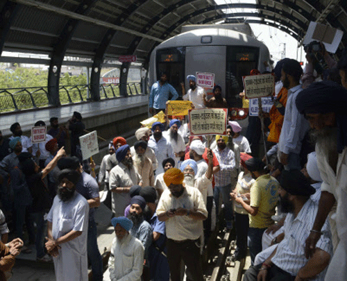 Sikh protestors stop the metro train as they protest against the acquittal of Congress politician Sajjan Kumar, at Tilak Nagar metro station in New Delhi on May 1, 2013. A court in New Delhi on Tuesday acquitted a ruling party politician of murder in a trial linked to the massacre of Sikhs following the 1984 assassination of then Indian prime minister Indira Gandhi. AFP PHOTO