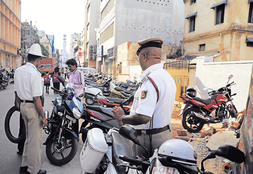 Traffic police officers book vehicle riders for wrong parking. DH Photo