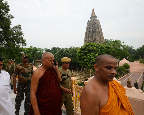 Buddhist monks and security officers walk after an explosion on the campus of the Mahabodhi Temple, the Buddhist Great Awakening temple, in Bodhgaya, about 130 kilometers (80 miles) south of Patna, the capital of the eastern Indian state of Bihar, Sunday, July 7, 2013. A series of small blasts hit three Buddhist temples in eastern India early Sunday, injuring at least two people, police said. (AP Photo