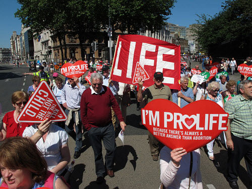 Anti-abortion protesters holding placards walk through Ireland's capital, Dublin, in an anti-abortion protest Saturday, July 6, 2013. More than 35,000 activists marched to the parliament building to oppose Irish government plans to enact a bill legalizing terminations for women in life-threatening pregnancies. The Protection of Life During Pregnancy Bill is expected to be passed into law next week. (AP Photo