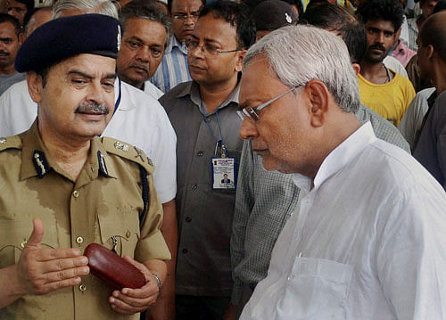 Bihar DGP Abhayanand discussing with Bihar Chief Minister Nitish Kumar after serial blast near Mahabodhi temple complex at Bodhgaya on Sunday. PTI photo