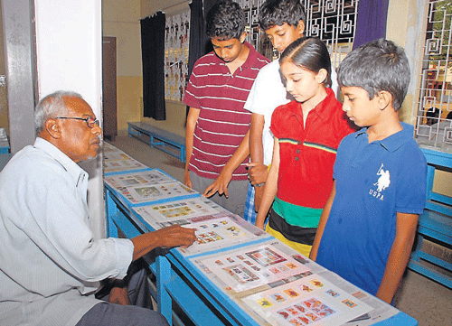 Philatelist Hanumanth Nayak exhibits stamps to students at an exhbition in Mysore, on Sunday. DH PHOTO