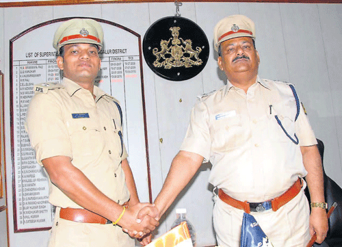Superintendent of Police N Shashikumar (left)who has been   transferred, shakes hand with the newly appointed Chikmagalur SP H R Nayak in Chikmagalur on Wednesday.