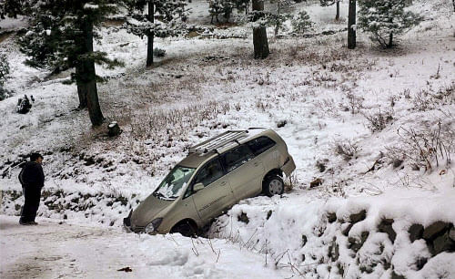A car stuck in a snow-clad area after snowfall at Gulmarg in Baramulla district . PTI Photo