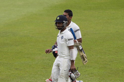 India's Cheteshwar Pujara (front) and Murali Vijay leave the field as bad light halts play during the first day of the second cricket test match against South Africa in Durban, December 26, 2013. REUTERS