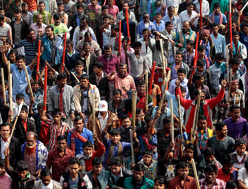 Supporters of the ruling Bangladesh Awami League armed with bamboo sticks march on a street to denounce opposition violence, in Dhaka, Bangladesh, Monday, Dec. 30, 2013. Ruling party supporters and their opponents threw stones at each other Monday on the second day of sporadic violence in the Bangladeshi capital, after heavy police presence foiled an opposition plan for a rally to pressure the government to scrap next month's election.  AP Photo/A.M. Ahad