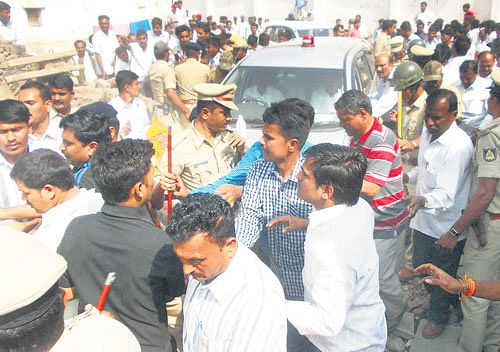 Anger and agony: People stop the vehicle of Home Minister K J George as he returns from the funeral of slain police sub-inspector Mallikarjun Bande (inset) at Khajuri in Aland taluk of Gulbarga district on Thursday.