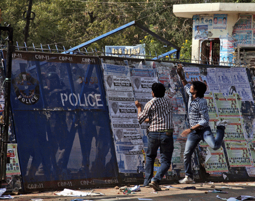 Students from Osmania University supporting the creation of a separate state of Telangana throws an iron bar gate at policemen from inside the university during a protest in Hyderabad. The Andhra Pradesh assembly, by a voice vote Thursday, rejected the Andhra Pradesh Reorganisation Bill 2013 on creating a separate Telangana state. AP File Photo