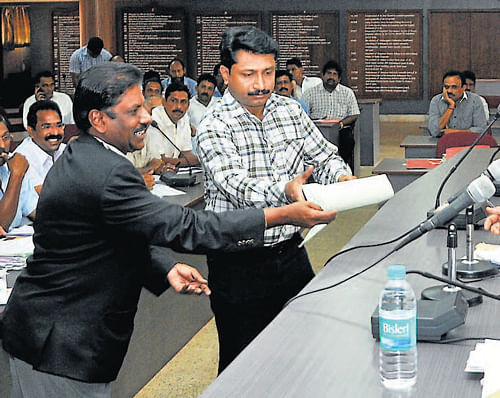 An advocate representing Canara Bus Owners' Association submits before the District                 Magistrate at the Regional Transport Authority meeting at the DC's office in Mangalore  on Thursday. DH Photo