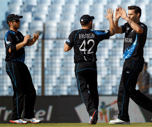 New Zealand's Mitchell McClenaghan, right, celebrates with his team captain-Brendon McCullum, center, after taking the wicket of Netherlands' Wesley Barresi during their ICC Twenty20 Cricket World Cup match in Chittagong, Bangladesh, Saturday, March 29, 2014. (AP Photo/A.M. Ahad)