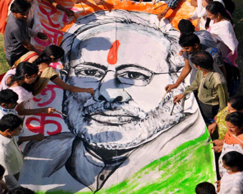 : Students of a degree college prepare a 26-feet long poster of Prime Minister-designate Narendra Modi ahead of his swearing-in ceremony in Moradabad on Sunday. PTI Photo