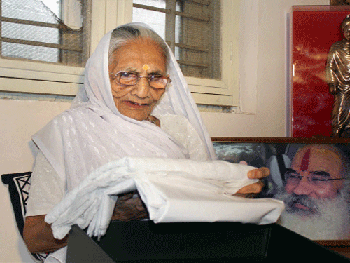 Prime Minister Narendra Modi's mother Hiraba looking at the 'Sari' sent for her by Pakistani Prime Minister Nawaz Sharif as a gift, in Gandhinagar on Thursday. PTI photo