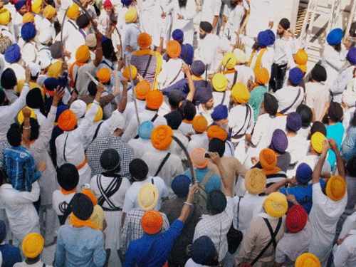 Sikh men brandishing swords during a clash between SGPC supporters and a radical Sikh organisation on the 30th anniversary of Operation Bluestar, at Golden Temple Complex in Amritsar. PTI photo
