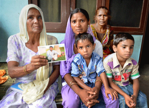 family members of Sonu, believed to be trapped in the troubled city of Mosul (Iraq), showing his sons photograph in Amritsar. PTI photo