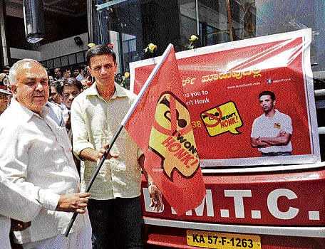 Former India captain Rahul Dravid flags off a Volvo bus carrying an anti-honking message in the City on Friday. Transport Minister Ramalinga Reddy is seen. DH photo