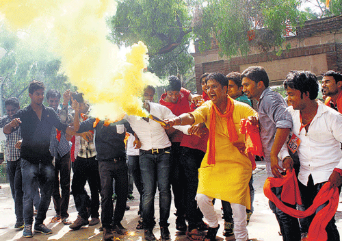 Students celebrate the Delhi University's decision to drop the controversial four-year UG course in New Delhi on Friday.  DH photo