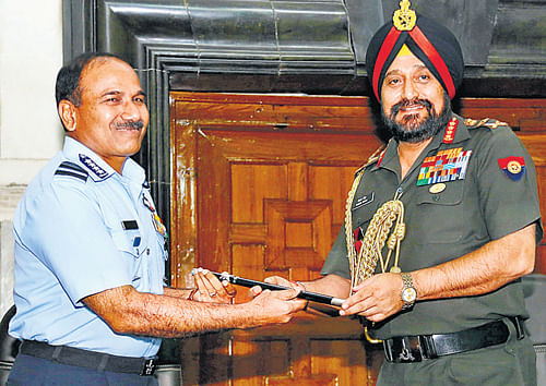 Army Chief General Bikram Singh hands over the chief of staff baton to IAF Chief Air Chief Marshall Arup Raha, the new chief of staff, in the South Block on Wednesday.