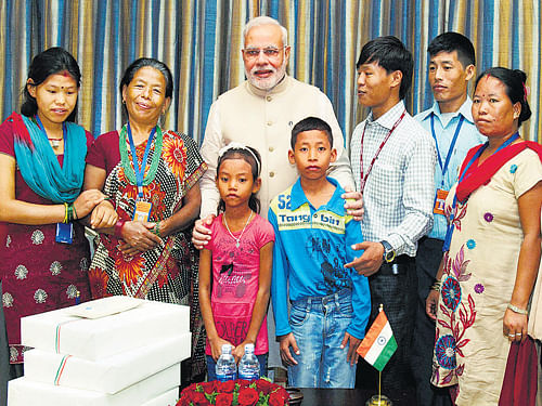 Prime Minister Narendra Modi with the family of Jeet Bahadur (3R) in Kathmandu, Nepal on Sunday. The young boy has been raised by the PM in Gujarat, India. PTI