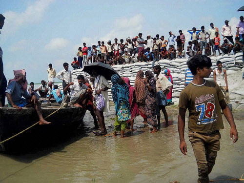 Flood affected villagers waiting to be rescued as danger to Kosi's embankments rose after heavy inflow of water into the river from Nepal's side in Saharsa district of Bihar on Monday. PTI Photo