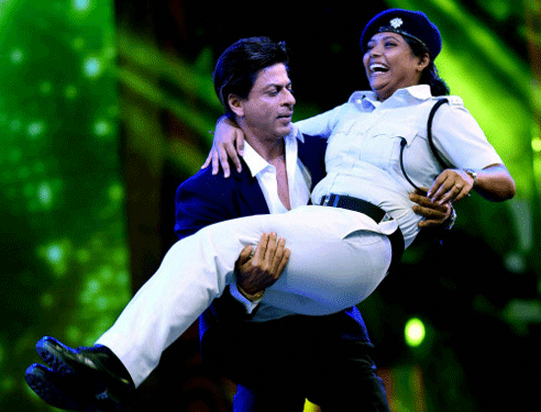 Bollywood actor Shahrukh Khan lifts a lady Police Constable at a dance sequence during Kolkata Police Programme in Kolkata on Saturday late evening. PTI Photo