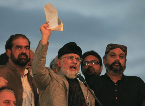 Tahir ul-Qadri, Sufi cleric and leader of political party Pakistan Awami Tehreek (PAT), displays a document to supporters while speaking to them in front of the Parliament House building during the Revolution march in Islamabad. Reuters photo