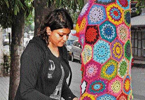 Artist Smera covers a tree with her woollen creation on  Museum Road. dh photo