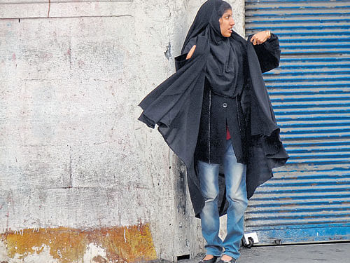 A girl in jeans wearing hijab.