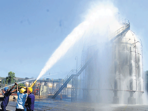 Fire fighters try to extinguish fire at an off-site mock drill organised as a part of Chemical Disaster Prevention Day, to commemorate the Bhopal gas tragedy, at the BPCL premises in Mangaluru on Thursday. Dh photo