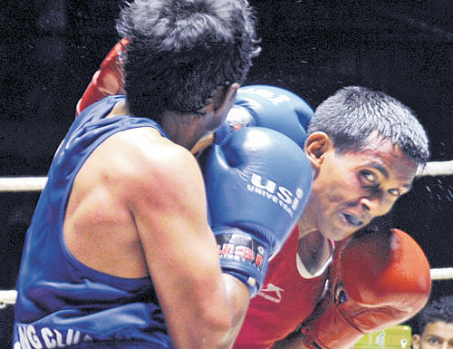 Fierce fight: MEG's Y V Ramana ( right) battles with IBC's Bharath during the State Boxing Championship at the Sree Kanteerava Stadium in  Bengaluru on Monday. dh photo
