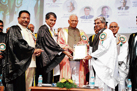 Governor Vajubhai Vala confers honorary doctorate on Shyama Raju, Chancellor of Reva University, Bengaluru, during the VTU convocation in Belagavi on Saturday. Railway Minister Suresh Prabhu, scientist Dr V K Aatre, and VTU Vice Chancellor Dr H Maheshappa are present. DH PHOTO
