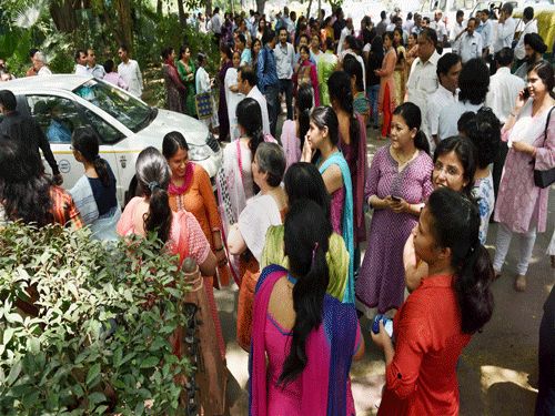 People come out of SBI building after earthquake in New Delhi on Tuesday. PTI Photo.