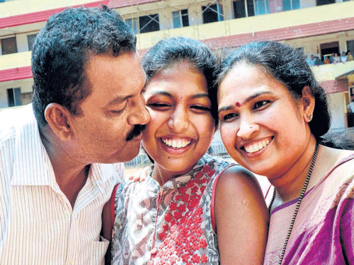 Rashmitha, the first position holder in Commerce, is greeted by her parents.