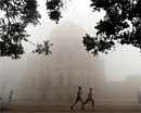 Men jog amidst thick fog in New Delhi on Friday. AFP