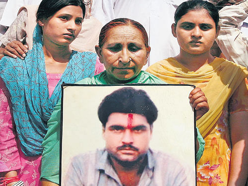 Members of Sarabjit Singh's family with his photo.