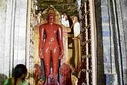 The statue of Shantinatha Swamy being anointed with  chandana  at Halebeedu in Hassan on Sunday. dh photo