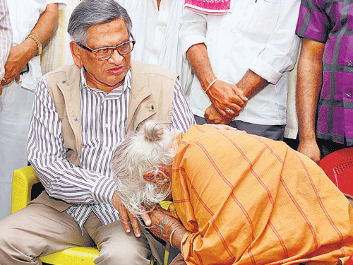 Former chief minister S&#8200;M&#8200;Krishna consoles Muttamma, the mother of farmer Shivalingegowda who committed suicide recently, at her house at Honnanayakanahalli in Mandya taluk on Friday.  DH PHOTO