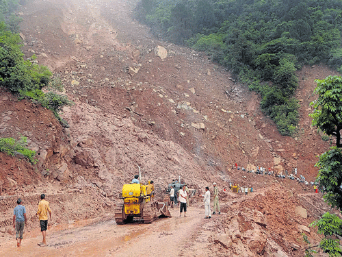 Slush being cleared from the Jammu-Srinagar National Highway after landslides triggered by heavy rain in Udhampur on Saturday. PTI