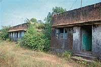 Gathering Dust: A view of government quarters behind SPs house in Madikeri. (Inset) The dilapidated condition of the doors at quarters. DH Photo
