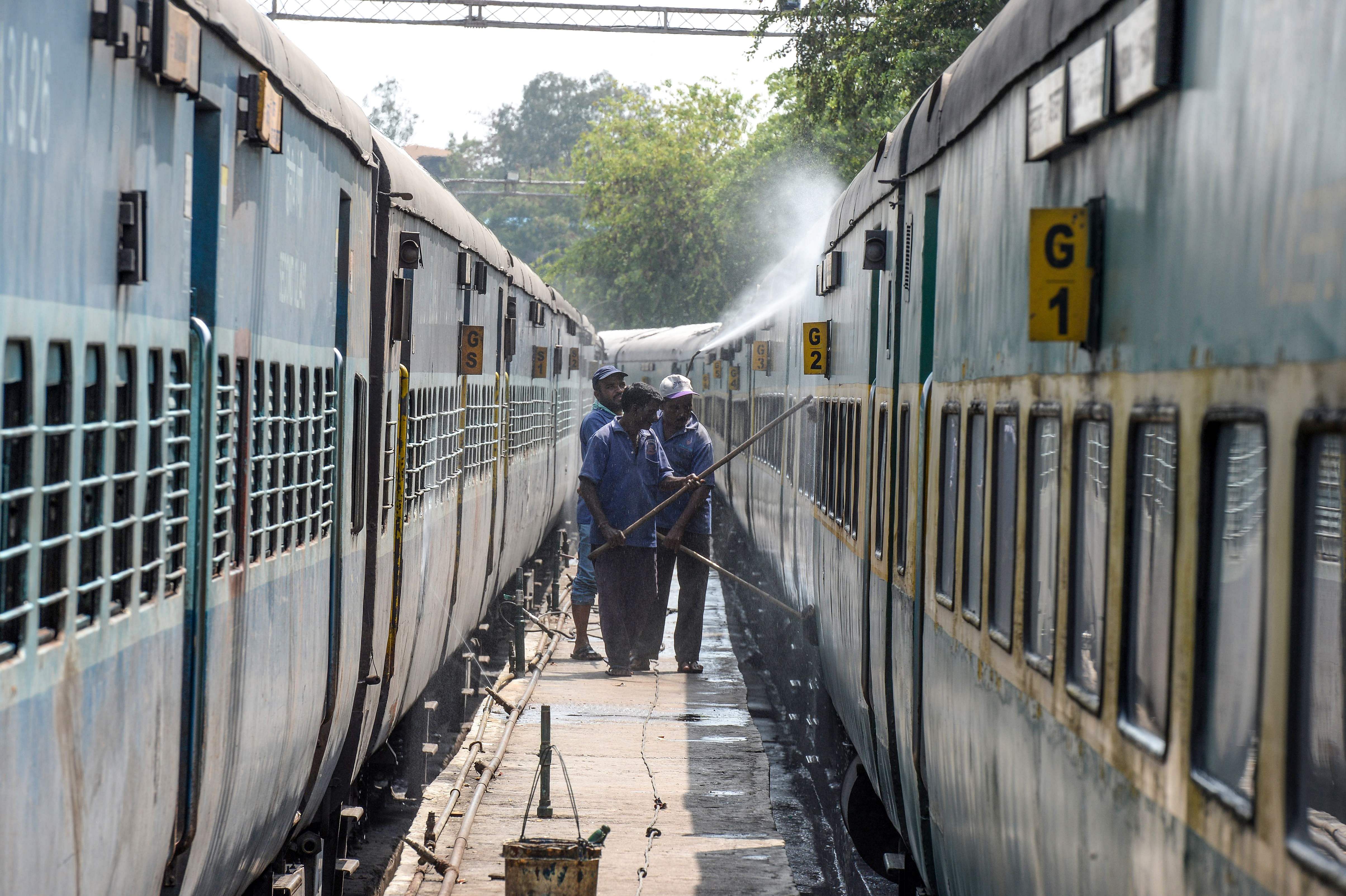 Workers clean the coaches of a train amid concerns over the spread of the COVID-19 novel coronavirus at a railway station in Secunderabad, the twin city of Hyderabad. (AFP Photo)