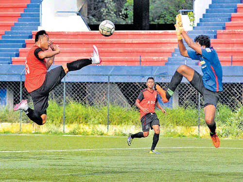 Acrobatic: ASC's Jotin Singh (left) tries to score past RWF's goalkeeper Arun during their  Super Division tie at the Bangalore Football stadium in Bengaluru on Thursday. dh photo